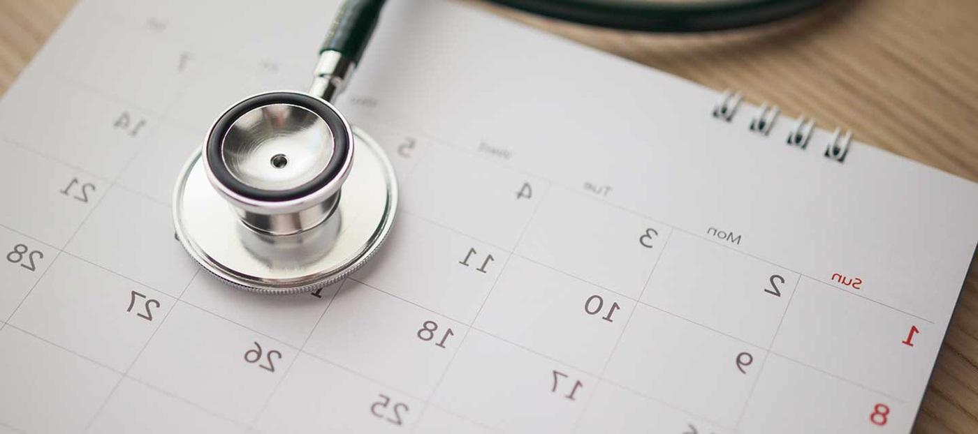 stethoscope sitting atop a monthly calendar
