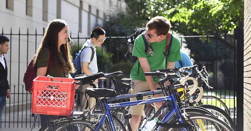 student locking up bike on campus